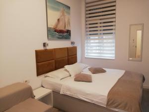 une chambre avec un lit avec des draps blancs et une fenêtre dans l'établissement Apartment Perla, à Zagreb