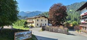 a view of a house with a fence and mountains at Haus Thussn, Ferienwohnung für Familien und Paare in Kirchberg in Tirol