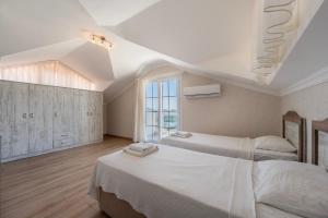 una camera da letto con due letti e una grande finestra di Ölüdeniz, Villa Solvento a Fethiye Altre 42 foto