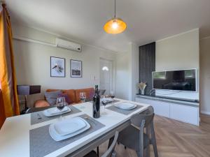 a kitchen and living room with a table and chairs at Cecilia Apartments - stunning sea views and relaxing Mediterranean getaway in Lun +14 photos