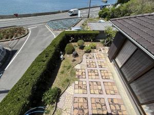 eine Draufsicht auf einen Garten mit einer Straße und einem Gebäude in der Unterkunft Oyado UmiSora - Vacation STAY 32774v in Kami Amakusa + 17 Fotos