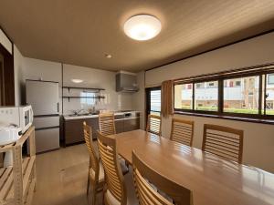 eine Küche mit einem großen Holztisch und Stühlen in der Unterkunft Oyado UmiSora - Vacation STAY 32774v in Kami Amakusa