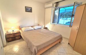 a small bedroom with a bed and a window at Studio Apartmani Šehić in Krvavica