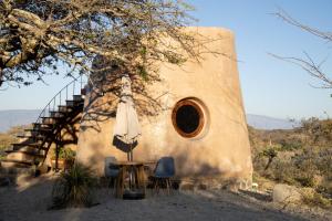 a building with a table and an umbrella and a staircase at Rancho Sol Rosa in La Becerrera