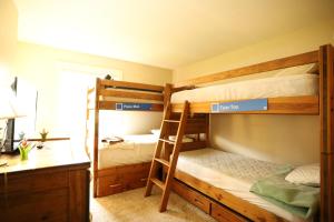 Un dormitorio con dos literas y un escritorio. en Sunnyside 9, WV, en Waterville Valley