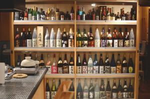 Oyado Tototo - Vacation STAY 37451v في Akune: رف مملوء بالكثير من زجاجات النبيذ