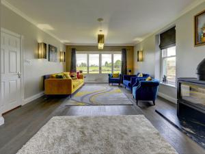 a living room with a yellow couch and blue chairs at The Farm House in Richmond