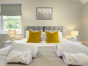 a bedroom with a large white bed with yellow pillows at The Farm House in Richmond