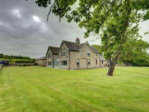 an old stone house with a large grass yard at The Farm House in Richmond