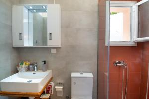 a bathroom with a sink and a toilet and a mirror at Sueño Central Apartments in Gaios +7 photos