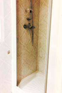 a shower with a shower head in a bathroom at T1 au coeur de St Florent in Saint-Florent