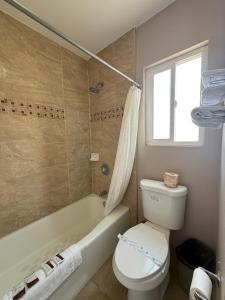un bagno con un water, una vasca e un lavandino di Torch Lite Lodge a Yuma