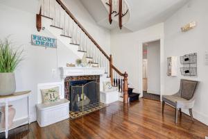 a living room with a fireplace and a staircase at The Hewitt Wellington Hotel in Spring Lake