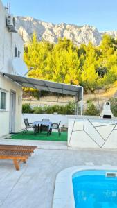 a patio with a table and a swimming pool at Studio Apartmani Šehić in Krvavica