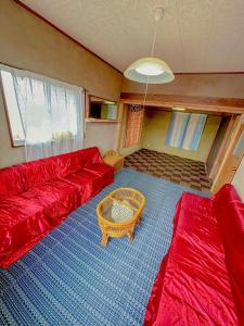 a living room with a red couch and a table at YAMAGAWA Okesho - Vacation STAY 38332v in Niijimamura