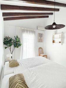 a bedroom with a white bed and wooden beams at NEW villa - luxury, views, hot tub, pool, 8 plus sofabed in Cómpeta +14 photos