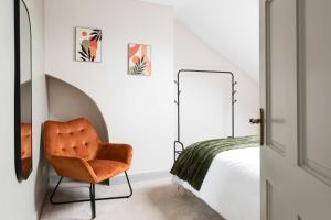 a bedroom with a chair next to a bed at 1BR/3BR Apartments in Bangor - Mins to Seafront & High St. in Bangor