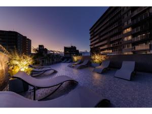 a rooftop patio with chairs and lights at night at SAUNA HOTEL GIFU - Vacation STAY 48263v in Gifu
