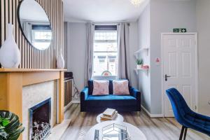 a living room with a blue couch and a mirror at St Helens Central, 2 Bed , Long Stays OFFERS , Contractors , Relocations , Families , Sleeps 4 in Saint Helens