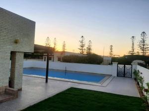 a swimming pool in the backyard of a house at Blue calm chalet in Dawwār Abū Maḩrūs
