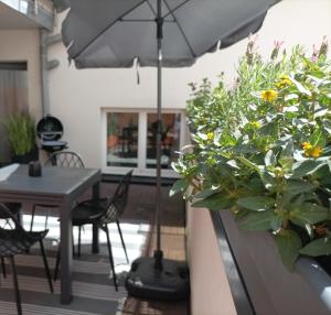 a patio with a table and chairs and an umbrella at Altbauoase Fulda - ruhig, zentral, Terrasse, Bahnhof 400m - in Fulda