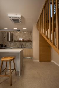 a kitchen with a staircase and a table and a stool at Vila Oliva i Terakota in Mandre