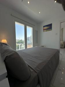 a bedroom with a large bed with a large window at Lumière Retreat 2 in Larnaka +7 photos