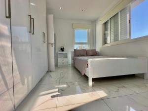 a white bedroom with a bed and a window at Lumière Retreat 2 in Larnaca +20 photos