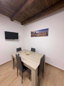 mesa de comedor con sillas y TV de pantalla plana en La Dimora del CAPO, en Palermo