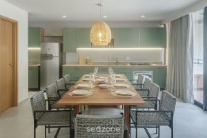 a dining room with a wooden table and chairs at Apto Moderno c/ piscina e 3 suítes - VKA0115 in Tatuamunha