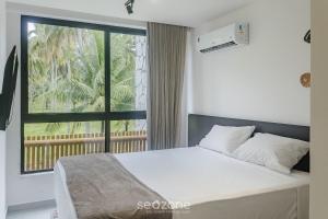 a bedroom with a bed and a large window at Apto Moderno c/ piscina e 3 suítes - VKA0115 in Tatuamunha +20 photos