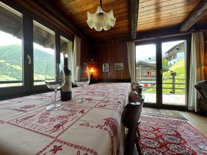 a dining room with a table with wine glasses at Chalet les Mélèzes - Typique, terrasse & cheminée in Liddes +41 photos