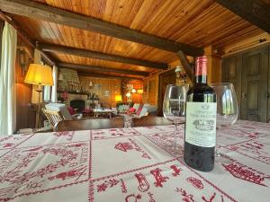 a bottle of wine sitting on top of a table at Chalet les Mélèzes - Typique, terrasse & cheminée in Liddes