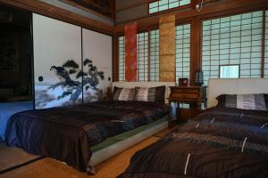 una camera con due letti in una stanza con finestre di 星が綺麗な町の古民家 Kominka いすみ市 a Shiigi