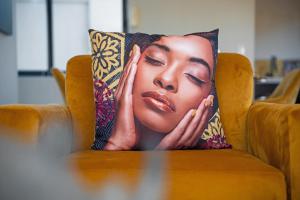 a pillow with a picture of a woman on a chair at Knightsbridge Terrace in Cape Town
