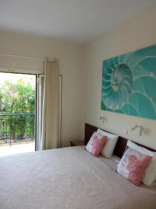 a bedroom with a bed with pink and white pillows at Metaxa Apartments in Kavos +43 photos