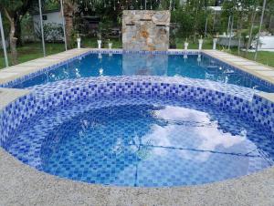 a swimming pool with blue tiles on it at Farm 110 Resort in Amadeo