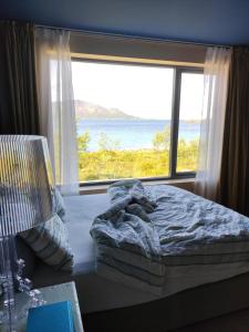 a bedroom with a bed and a large window at Villa by the sea in Vesterålen 