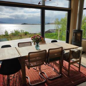 a dining room table with chairs and a large window at Villa by the sea in Vesterålen 