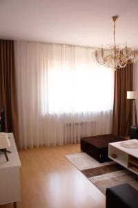 een woonkamer met een bed en een groot raam bij Apartment Emmi in Sarajevo