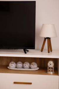 een tv op een plank met een lamp en wat klokken bij Apartment Emmi in Sarajevo +39 foto's