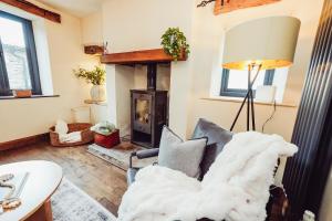 a living room with a couch and a fireplace at Cottage near Matlock Bath & Cromford in Middleton