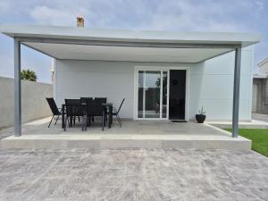 a pavilion with a table and chairs on a patio at Casitalola in Conil de la Frontera