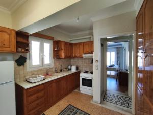 a kitchen with wooden cabinets and a sink and a stove at Port House Apartment in Zakynthos