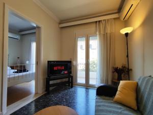 a living room with a tv and a couch at Port House Apartment in Zakynthos