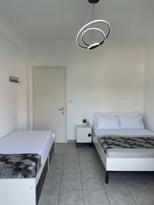 a bedroom with two beds and a chandelier at Callisti Lux Apartment in Nei Poroi