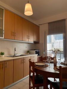 a kitchen with a table and a dining room at Callisti Lux Apartment in Nei Poroi