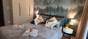 Un dormitorio con una cama con toallas. en Sea & Forest - Apartamenty Może nad Morze, Parking, basen, siłownia GRATIS, en Międzyzdroje 39 fotos más