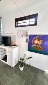 a room with a desk with a computer and a painting at Suites Palmar - Praia da Biscaia in Angra dos Reis +18 photos