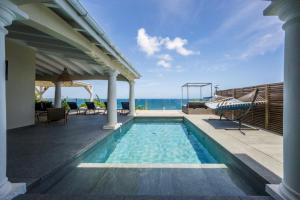 ein Swimmingpool mit Blick auf das Meer in der Unterkunft Villa d'Happy Bay - Panoramic View of Caribbean and sunsets in Friar's Bay